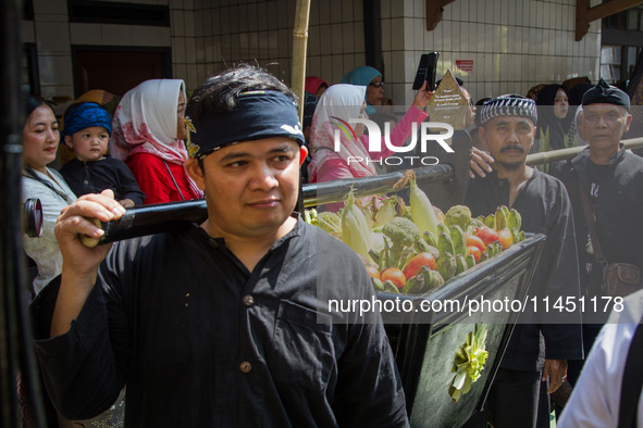 Cireundeu Indigenous people are bringing the 'Gunungan', a sacrifice in the shape of a mountain, during the Ngemban Taun traditional ceremon...