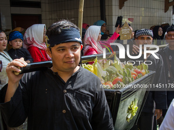 Cireundeu Indigenous people are bringing the 'Gunungan', a sacrifice in the shape of a mountain, during the Ngemban Taun traditional ceremon...