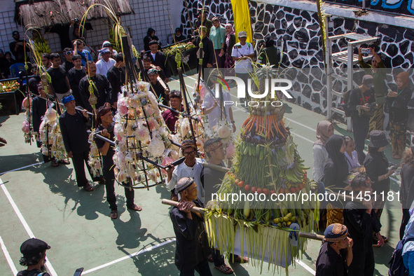 Cireundeu Indigenous people are bringing the 'Gunungan', a sacrifice in the shape of a mountain, during the Ngemban Taun traditional ceremon...