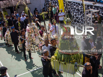 Cireundeu Indigenous people are bringing the 'Gunungan', a sacrifice in the shape of a mountain, during the Ngemban Taun traditional ceremon...