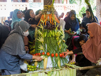 People are jostling the 'Gunungan', a sacrifice in the shape of a mountain, during the Ngemban Taun traditional ceremony in Cireundeu Villag...