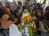 People are jostling the 'Gunungan', a sacrifice in the shape of a mountain, during the Ngemban Taun traditional ceremony in Cireundeu Villag...