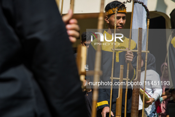 The Cireundeu Indigenous people are performing Angklung Buncis during the Ngemban Taun traditional ceremony in Cireundeu Village, West Java,...