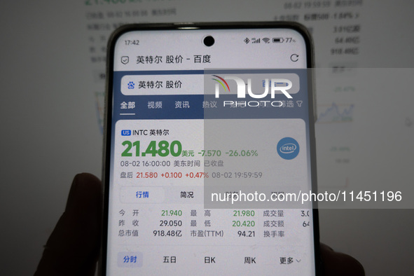 A young man is checking the share price of Intel on his mobile phone and computer in Shanghai, China, on August 3, 2024. Intel shares are fa...