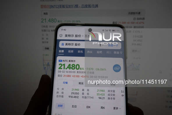 A young man is checking the share price of Intel on his mobile phone and computer in Shanghai, China, on August 3, 2024. Intel shares are fa...