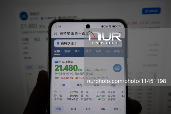 A young man is checking the share price of Intel on his mobile phone and computer in Shanghai, China, on August 3, 2024. Intel shares are fa...