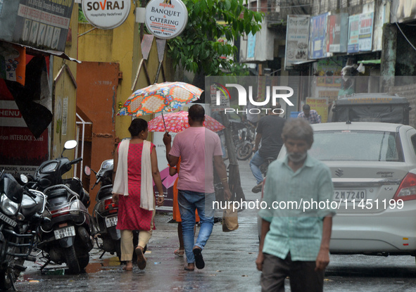 People are using umbrellas as they walk during a continuous rainfall in Siliguri, India, on August 3, 2024. 