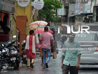 People are using umbrellas as they walk during a continuous rainfall in Siliguri, India, on August 3, 2024. (