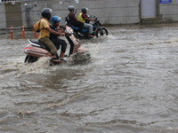 A motorcycle is wading through the waterlogged busy road during the heavy monsoon rain in Kolkata, India, on August 3, 2024. (