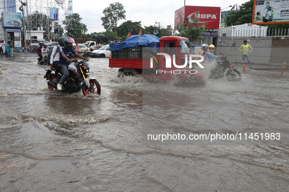 Commuters are wading through the waterlogged busy road during heavy monsoon rain in Kolkata, India, on August 3, 2024. 