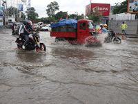 Commuters are wading through the waterlogged busy road during heavy monsoon rain in Kolkata, India, on August 3, 2024. (