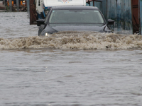 Commuters are wading through the waterlogged busy road during heavy monsoon rain in Kolkata, India, on August 3, 2024. (