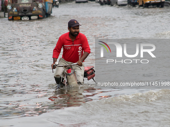 A Zomato food delivery boy is riding his bicycle through the waterlogged busy road during the heavy monsoon rain in Kolkata, India, on Augus...