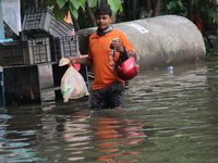 A Swiggy food delivery boy is walking through a flooded street during the heavy monsoon rain in Kolkata, India, on August 3, 2024. (