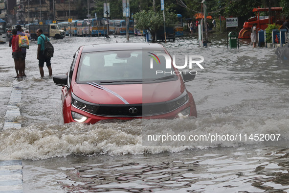 Vehicles are driving through a flooded street during the heavy monsoon rain in Kolkata, India, on August 3, 2024. 