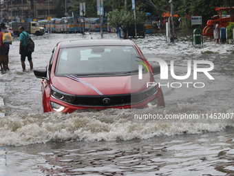 Vehicles are driving through a flooded street during the heavy monsoon rain in Kolkata, India, on August 3, 2024. (