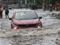 Vehicles are driving through a flooded street during the heavy monsoon rain in Kolkata, India, on August 3, 2024. (