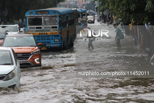 Vehicles are driving through a flooded street during the heavy monsoon rain in Kolkata, India, on August 3, 2024. 