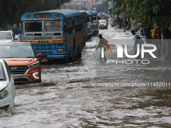 Vehicles are driving through a flooded street during the heavy monsoon rain in Kolkata, India, on August 3, 2024. (