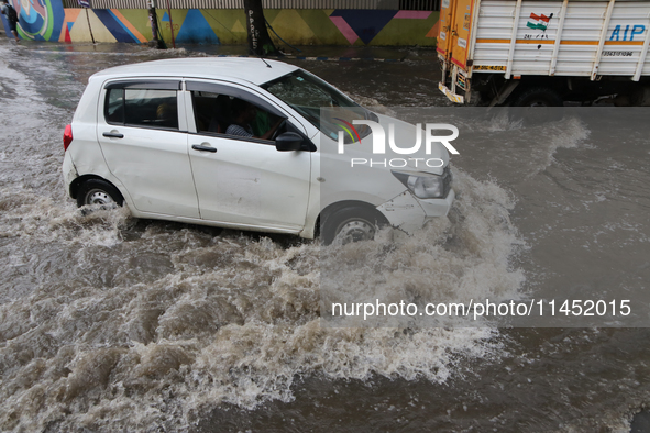 Vehicles are driving through a flooded street during the heavy monsoon rain in Kolkata, India, on August 3, 2024. 