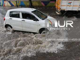 Vehicles are driving through a flooded street during the heavy monsoon rain in Kolkata, India, on August 3, 2024. (