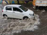 Vehicles are driving through a flooded street during the heavy monsoon rain in Kolkata, India, on August 3, 2024. (