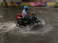 A Zomato delivery person is being seen on a flooded street during the heavy monsoon rain in Kolkata, India, on August 3, 2024. (