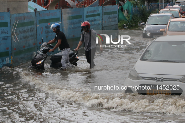 Vehicles are driving through a flooded street during the heavy monsoon rain in Kolkata, India, on August 3, 2024. 