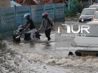 Vehicles are driving through a flooded street during the heavy monsoon rain in Kolkata, India, on August 3, 2024. (