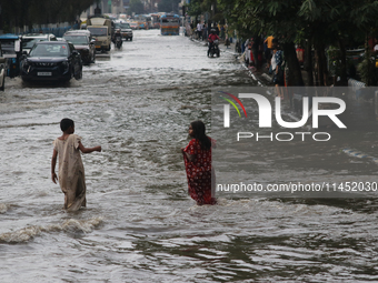 Vehicles are driving through a flooded street during the heavy monsoon rain in Kolkata, India, on August 3, 2024. (