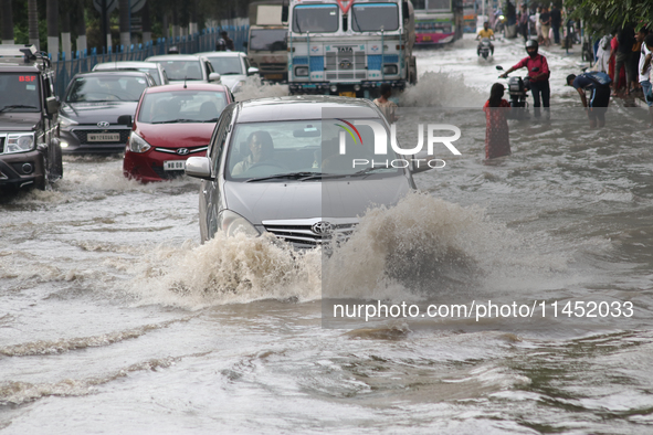 Vehicles are driving through a flooded street during the heavy monsoon rain in Kolkata, India, on August 3, 2024. 