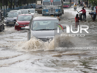 Vehicles are driving through a flooded street during the heavy monsoon rain in Kolkata, India, on August 3, 2024. (