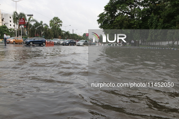 Commuters are wading through the waterlogged busy road during heavy monsoon rain in Kolkata, India, on August 3, 2024. 