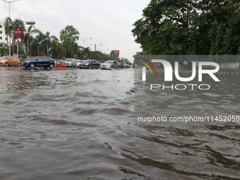 Commuters are wading through the waterlogged busy road during heavy monsoon rain in Kolkata, India, on August 3, 2024. (