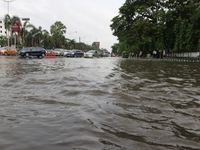 Commuters are wading through the waterlogged busy road during heavy monsoon rain in Kolkata, India, on August 3, 2024. (