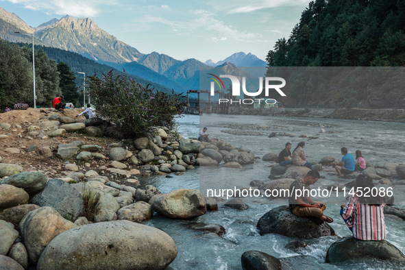 Tourists are enjoying in River Lidder on a hot summer day in Pahalgam, Jammu and Kashmir, India, on August 3, 2024. 