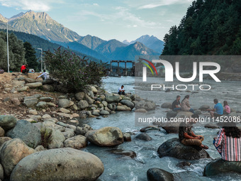 Tourists are enjoying in River Lidder on a hot summer day in Pahalgam, Jammu and Kashmir, India, on August 3, 2024. (