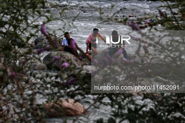 Tourists are enjoying in River Lidder on a hot summer day in Pahalgam, Jammu and Kashmir, India, on August 3, 2024. 