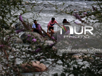 Tourists are enjoying in River Lidder on a hot summer day in Pahalgam, Jammu and Kashmir, India, on August 3, 2024. (