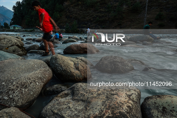 Tourists are enjoying in River Lidder on a hot summer day in Pahalgam, Jammu and Kashmir, India, on August 3, 2024. 