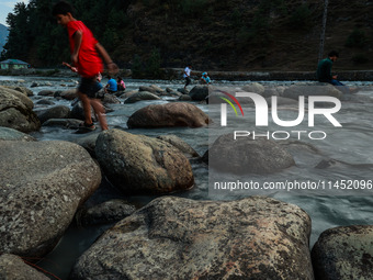 Tourists are enjoying in River Lidder on a hot summer day in Pahalgam, Jammu and Kashmir, India, on August 3, 2024. (