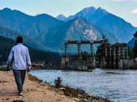 A man is walking as a power project is being seen on the banks of River Lidder in Pahalgam, Jammu and Kashmir, India, on August 3, 2024. (