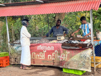 A man is purchasing fish from a roadside stand selling fresh fish and prawns in Adoor, Pathanamthitta, Kerala, India, on April 06, 2024. (