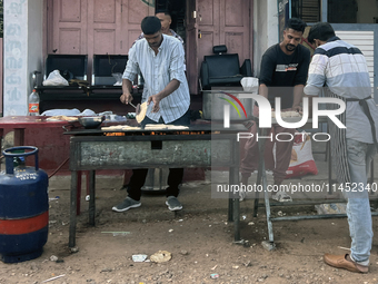 Men are preparing parotta bread along the roadside during Ramadan in Kerala, India, on April 10, 2024. (