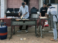 Men are preparing parotta bread along the roadside during Ramadan in Kerala, India, on April 10, 2024. (