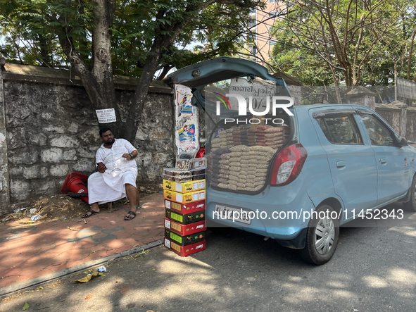 A man is selling nuts and dried fruits from the back of a vehicle along the roadside in Thiruvananthapuram (Trivandrum), Kerala, India, on M...