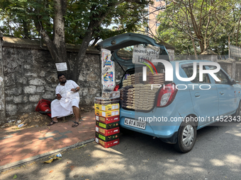 A man is selling nuts and dried fruits from the back of a vehicle along the roadside in Thiruvananthapuram (Trivandrum), Kerala, India, on M...