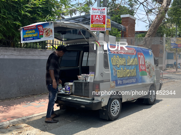 A man is selling pre-made biryani from the back of a vehicle along the roadside in Thiruvananthapuram (Trivandrum), Kerala, India, on March...