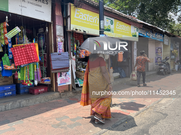 A woman is using an umbrella to protect herself from the hot sun in Thiruvananthapuram (Trivandrum), Kerala, India, on March 31, 2024. 