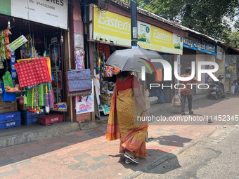 A woman is using an umbrella to protect herself from the hot sun in Thiruvananthapuram (Trivandrum), Kerala, India, on March 31, 2024. (